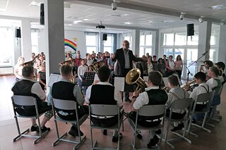 Jugendliche einer Blaskapelle spielen vor Publikum.