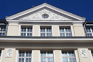 Fassade mit Giebel vor blauem Himmel