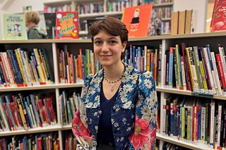 Lina vor einem Bücherregal