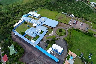 Luftansicht des Schulgebäudes, mehrere Trakte, umgeben von Grünflächen