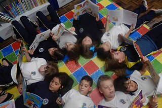 Kinder liegen auf dem Fußboden und lesen.