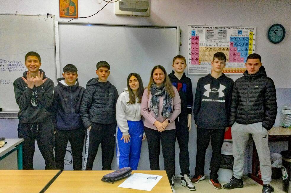 Eine kleine Gruppe Jugendlicher mit einer Lehrkraft in einem Klassenzimmer