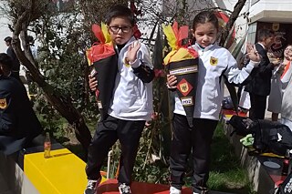 Zwei Erstklässler mit Schultüten grüßen etwas schüchtern in die Kamera.