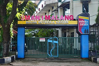 Gebäude, Haupteingang mit vielen Pflanzen und Blumen