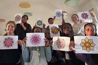 Jugendliche zeigen stolz die selbst erstellten Mandalas in die Kamera.