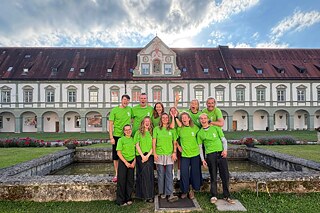 Junge Menschen vor einem Klostergebäude
