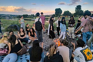 Jugendliche um ein Lagerfeuer an der Elbe