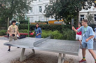 Jugendliche spielen Tischtennis.