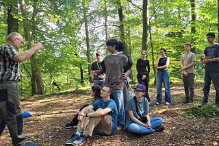 Jugendliche und ein Förster im Wald