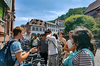 Jugendliche bei einer Führung über den Universitätsplatz in Heidelberg