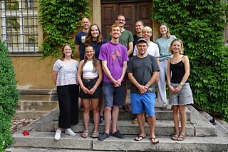 Junge Menschen auf einer Treppe vor einem Haus