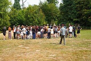 Eine große Gruppe Jugendlicher auf einer Wiese.
