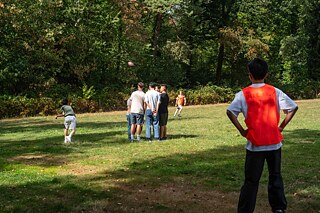 Jugendliche spielen Alaska American Football auf einer Wiese.