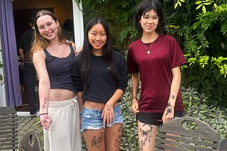 Drei junge Frauen präsentieren stolz ihre Henna-Tattoos.