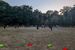 Jugendliche spielen auf einer Wiese.