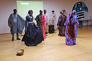 Jugendliche aus dem Senegal tanzen in Tracht.