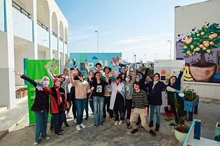 Lycée Pilote Nabeul Street Art. Eine Gruppe von Personen steht zusammen und lächelt in die Kamera.