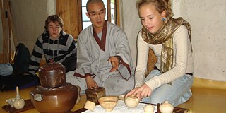 Eine Schülerin hilft einem Mönch bei einer traditionellen Teezeremonie. © privat Eine Schülerin hilft einem Mönch bei einer traditionellen Teezeremonie.