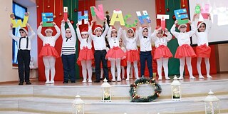 Schülerinnen und Schüler singen und tanzen bei der deutschen Weihnachtsfeier