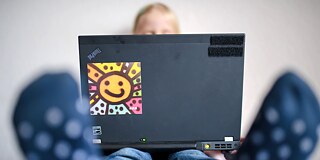 Ein Kind schaut auf einem Laptop einen Trickfilm