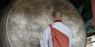 Ein Mönch schlägt einen Gong im Tempel Haeinsa. © privat Ein Mönch schlägt einen Gong im Tempel Haeinsa.