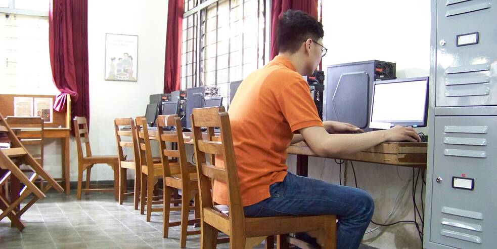 Hengky sitzt in der Schule Computerraum