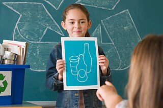 Gemeinsam an den Zielen für nachhaltige Entwicklung (SDG) arbeiten Eine Schülerin hält ein Plakat vor sich.