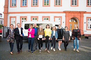 Schülerinnen und Lehrkräfte stehen vor dem PASCH-Mobil an der Mary-Ward-Schule