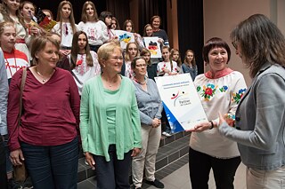 Katja Röhl (PAD) überreicht auch der ukrainischen Partnerschule die Partnerschafts-PASCH-Plakette 