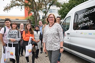 Schulleitung Frau Monika Nerreter mit Gastkindern vor dem PASCH-Mobil. 