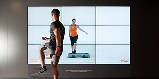 Ein Sportler absolviert in einem Fitnessstudio ein Cybertraining.