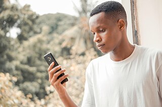 Ein Junge hält ein Smartphone in der Hand.