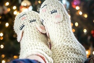 Flauschige Socken vor dem Weihnachtsbaum.