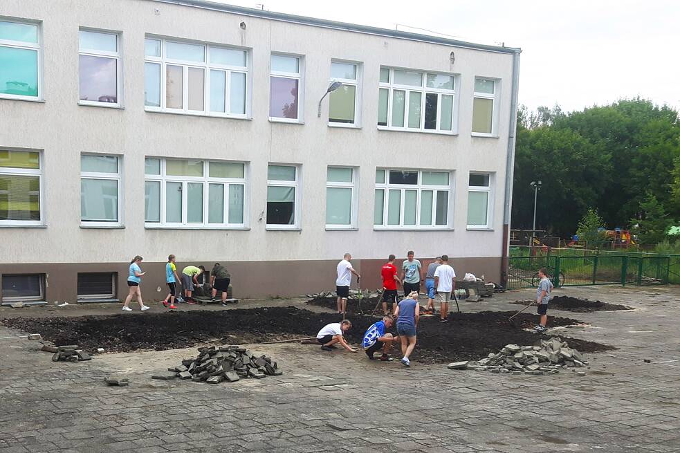 Schüler entfernen vor Ihrer Schule die Pflastersteine.