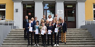 Gruppenbild vorm Haupteingang der Schule