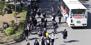 Schüler und Schülerinnen vor dem Schulbus