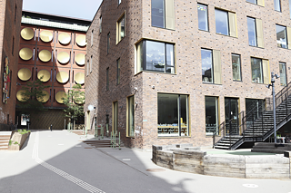 Schulgebäude aus hellen Ziegeln mit Treppe und Zufahrt