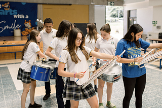 Eine Schülergruppe mit Instrumenten, in Schuluniform